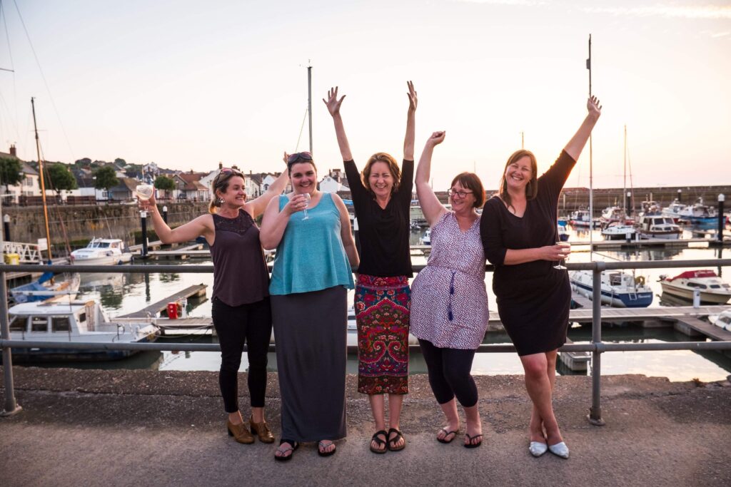 The Onion Collective team of Directors. 5 women standing in a row in a marina.