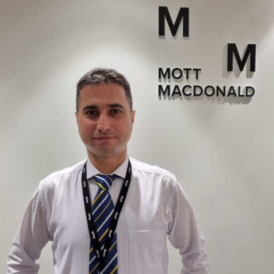 Mehdi-at-Work-in-front-of-Mott-Mac-logo