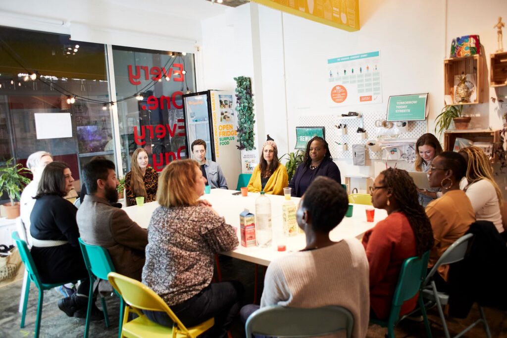 A group of community decision makers sitting around a table in discussion. 